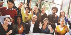 a group of people in the office, happily raising their hands to show support